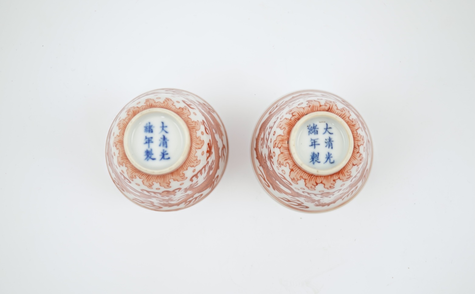 A pair of Chinese iron red ‘dragon’ cups, Guangxu six character mark and probably of the period (1875-1908)